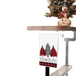 Weihnachts-Handtuch mit rot-schwarzen Karobäumen und Schriftzug am Holzregal hängend