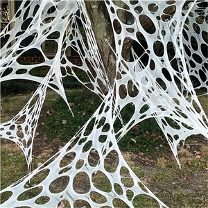Outdoor Halloween decoration featuring a giant white realistic spider web on a tree