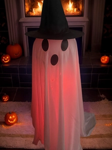 Close-up of a glowing Halloween ghost with a black wizard hat and soft red LED lighting