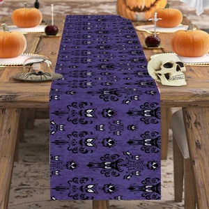 Purple Halloween table runner with bat patterns and spooky eyes on a wooden table