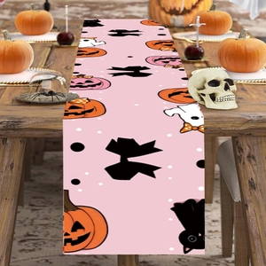 Pink Halloween table runner featuring cute pumpkin and ghost motifs on a wooden dining table