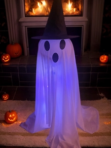 Close-up of glowing Halloween ghost with purple LED lights near a warm fireplace