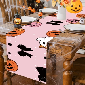 Pink Halloween table runner featuring pumpkins and ghosts on a wooden dining table