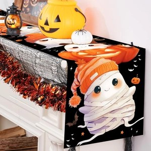 Detail of Halloween table runner with cartoon mummy and pumpkin on a decorated mantel