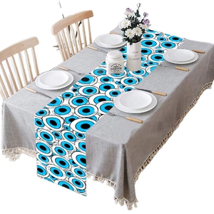 Halloween table runner with blue evil eye print and white fringe for party decor