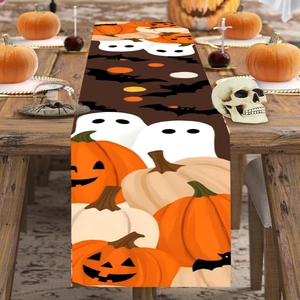 Halloween table runner featuring pumpkins ghosts and bats on a dark wooden table