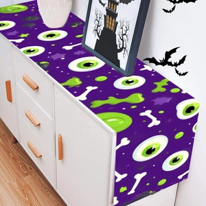 Halloween table runner featuring purple base with green eyes and bone patterns for party decor