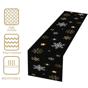 Close-up of black Christmas table runner with golden snowflakes and stars patterns