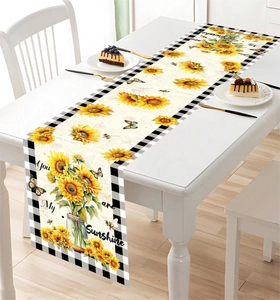 Detail of sunflower table runner with butterfly print and black white checkered borders