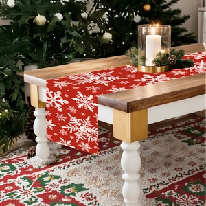 Christmas snowflake table runner in red fabric on a festive decorated wooden dinner table