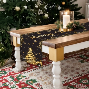 Black Christmas table runner with golden reindeer and tree patterns on a wooden table