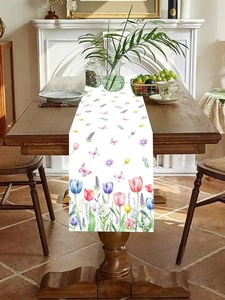 Close-up of floral table runner featuring colorful tulips and butterflies on white fabric