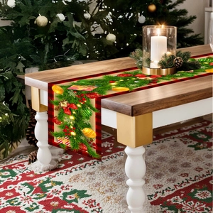 Close-up of a festive Christmas table runner with red and black plaid borders on wood