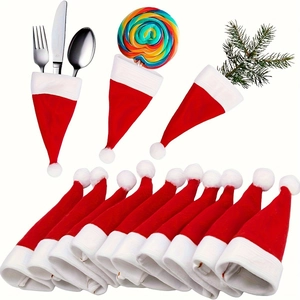 Mini red Christmas hat cutlery holders and festive party decorations on white background