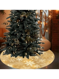Detail of gold Christmas tree skirt with white glitter snowflakes and festive texture