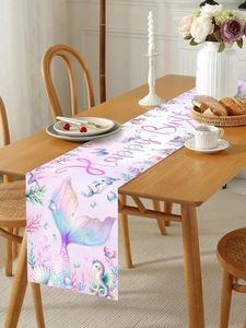 Detail of mermaid birthday table runner with ocean elements on a wooden dinner table