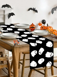 Detail of polyester Halloween table runner featuring cute white cartoon ghosts on black fabric