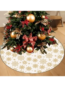 Close-up of white Christmas tree skirt featuring golden snowflake and star patterns