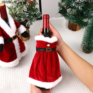 Detail of red velvet Christmas wine bottle covers with white plush trim and belts