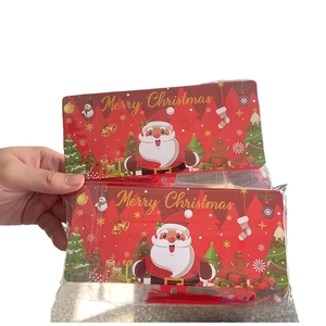 Close-up of red Merry Christmas gift bags with gold lettering and festive cartoon motifs
