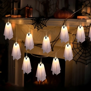 Detail of warm white LED ghost string lights hanging on a fireplace with Halloween decor