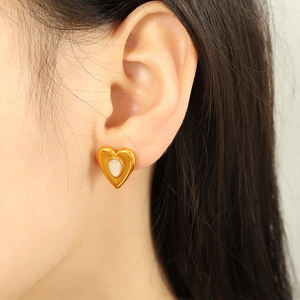 Elegante 18k vergoldete Herzohrringe mit weißem Inlay, präsentiert an einem Model