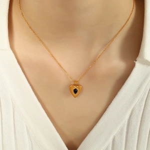 Elegante Herzkette mit schwarzem Edelstein-Inlay und Goldkette am Model getragen