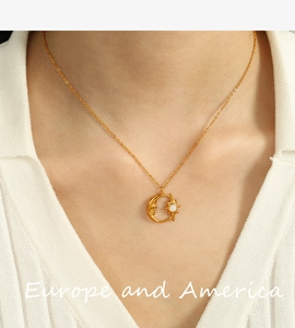 Primer plano del collar dorado con colgante de luna y estrella en la clavícula