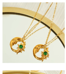Detalle del collar celestial dorado de luna y sol con piedra de ópalo verde