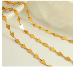 Close-up of golden geometric triangle link necklace with polished metallic finish