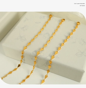 Detailed view of gold geometric triangle link bracelets with lobster clasp closure