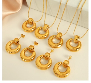 Macro shot of 18K gold plated minimalist round circle necklace and earring jewelry set