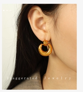 Close-up of model wearing exaggerated 18K gold plated thick round hoop earrings