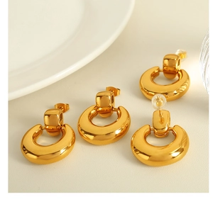 Macro detail of U-shaped high-polish 18K gold-plated metal drop earrings for women