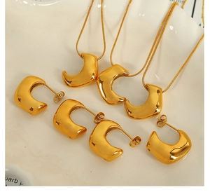 Detail of 18K gold plated horn pendant necklaces and matching stud earrings jewelry set