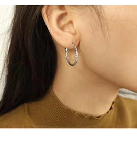 Nahaufnahme der strukturierten Silber-Creolen mit Diamantschliff-Muster an einem Model