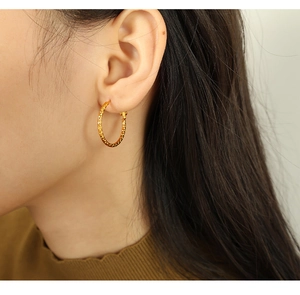 Detailansicht goldener gedrehter Creolen mit strukturierter Diamond-Cut-Oberfläche für Damen