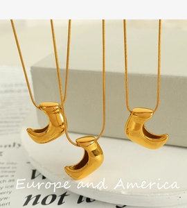 Detail of high-polished 18K gold-plated crescent pendants on delicate chain necklaces