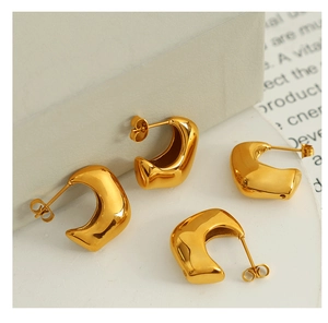 Polished 18K gold plated C-shaped chunky stud earrings displayed on minimalist props