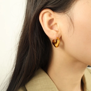 Polished 18K gold-plated irregular teardrop earrings worn by a model in modern style