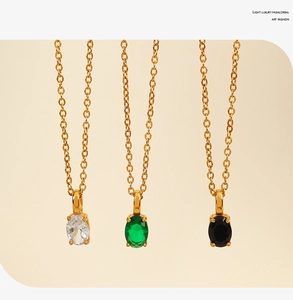 Detailed macro view of three oval-cut gemstone necklaces in gold claw settings