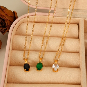 Elegant gold oval gemstone necklaces in green, black and white on velvet box