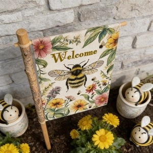Close-up of burlap garden flag with bee pattern and Welcome text on wooden pole