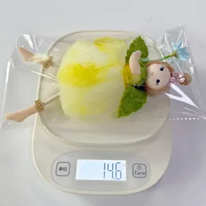Vue détaillée d'une poupée fée en tissu pesant 14,6g sur une balance numérique
