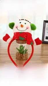 Détail d'un serre-tête de Noël avec bonhomme de neige en peluche, cache-oreilles et écharpe