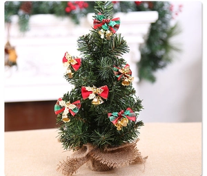 Detailansicht eines Mini-Weihnachtsbaums mit karierten Schleifen und goldenen Glocken