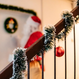 2M Christmas dark green garland with white snow edges wrapped on wooden staircase railings