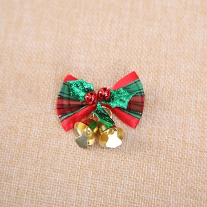Weihnachtsschleife im Karomuster mit Stechpalmenblättern, roten Beeren und Glöckchen
