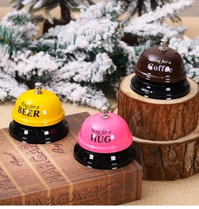 Detailed close-up of colorful metal service call bells on a rustic wooden background