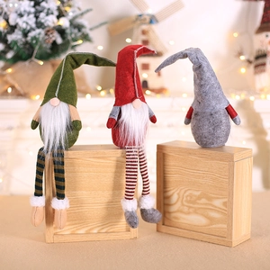 Three Nordic Christmas gnomes with pointed hats and long beards on wood decor